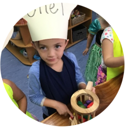 Child wearing chef hat playing with toys